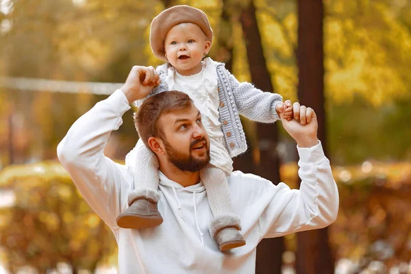 Knappe vader in een grijze trui spelen met kleine dochter in een herfst park — Stockfoto