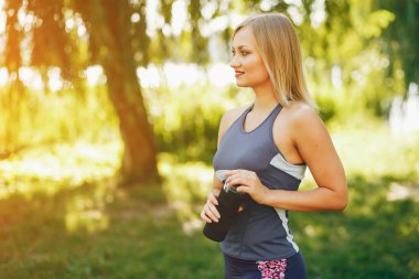 Güzel bir kız parkta sabah egzersiziyle meşgul..