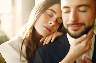 Takım elbiseli zarif çift bir kafede vakit geçiriyor.