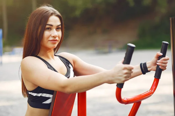 Sportmeisje in een zwarte top training in een zomerpark — Stockfoto