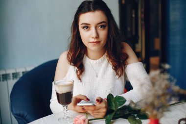 Kafede gül ve tatlı taşıyan bir kız.