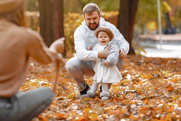 Família com pequena filha em um parque de outono — Fotografia de Stock