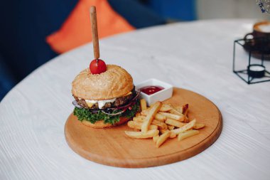 Bir kafede masada hamburger ve patates kızartması.
