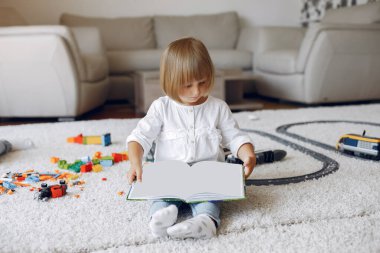 Çocuk oyun odasında kitapla oynuyor.