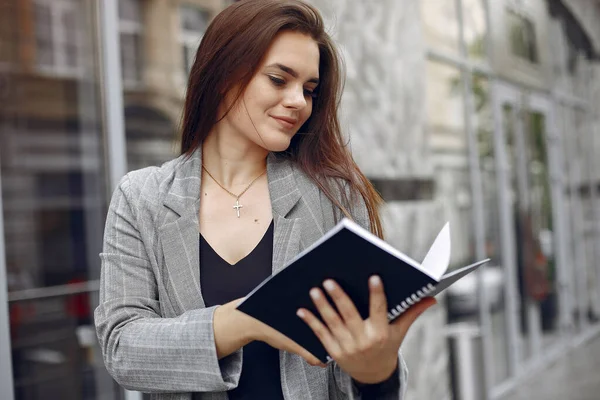 Elegante zakenvrouw die in een stad werkt en het notitieboekje gebruikt — Stockfoto