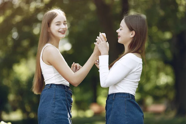 Due ragazze eleganti ed eleganti in un parco primaverile — Foto Stock