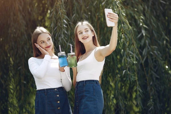 Due ragazze eleganti ed eleganti in un parco primaverile — Foto Stock