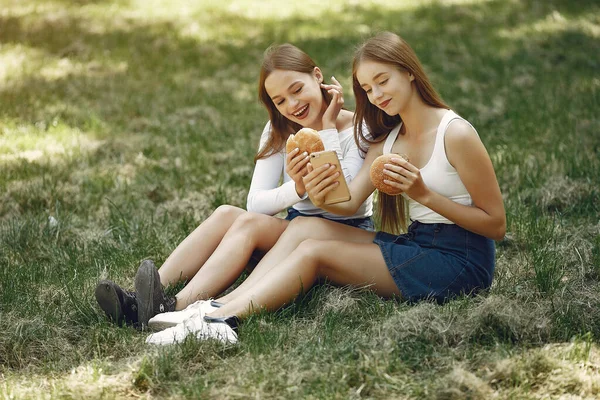 Two elegant and stylish girls in a spring park — Stock Photo, Image