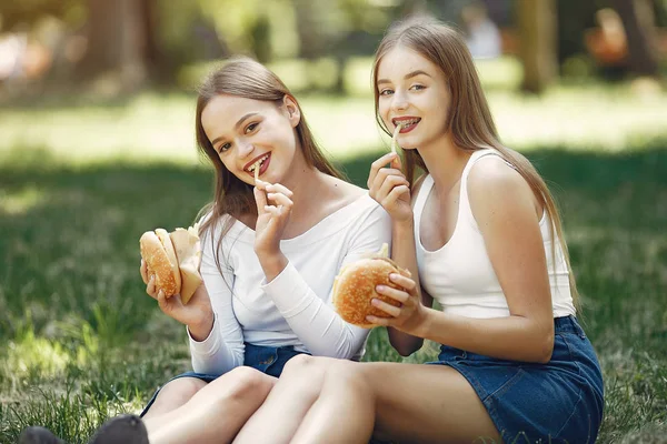 Due ragazze eleganti ed eleganti in un parco primaverile — Foto Stock