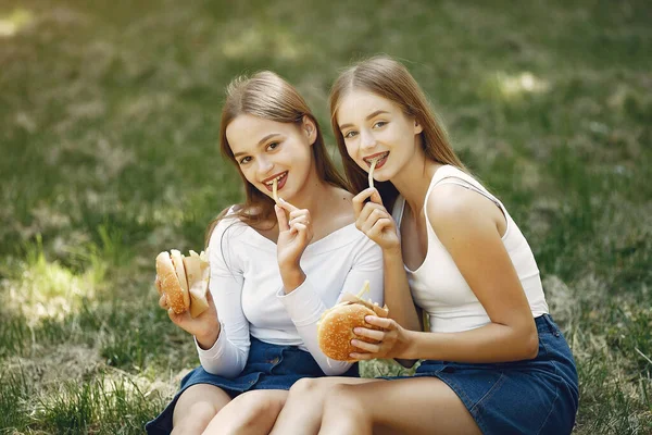 Due ragazze eleganti ed eleganti in un parco primaverile — Foto Stock
