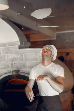 Beyaz üniformalı şef bir pizza hazırla.