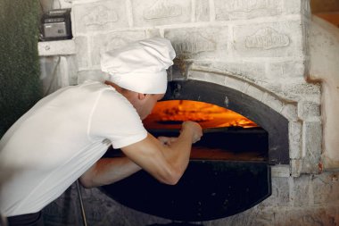 Beyaz üniformalı şef bir pizza hazırla.