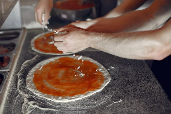 Kock i vit uniform förbereder pizzan — Stockfoto