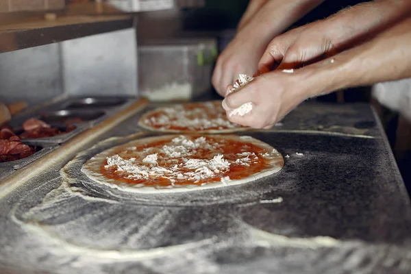 Kock i vit uniform förbereder pizzan — Stockfoto
