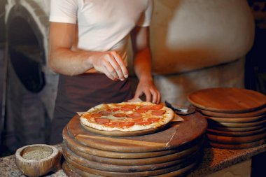 Beyaz üniformalı şef bir pizza hazırla.