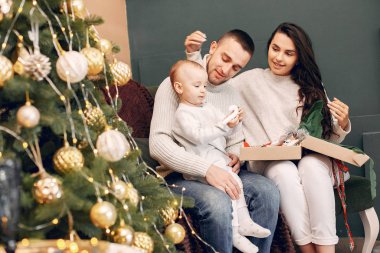 Aile Noel ağacının yanında oturuyor.