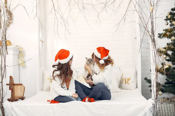 Yatakta oturan tatlı kızı olan bir anne.