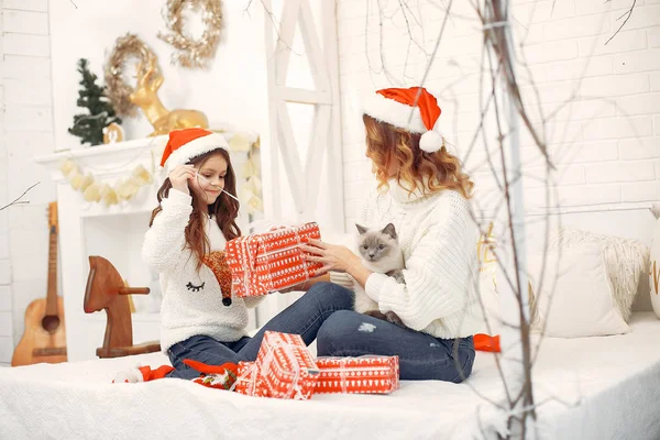 Yatakta oturan tatlı kızı olan bir anne.