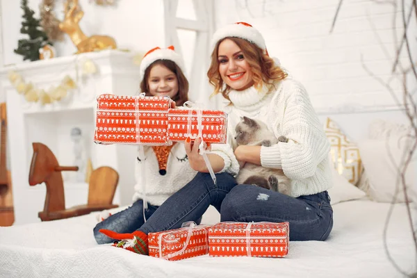 Yatakta oturan tatlı kızı olan bir anne.