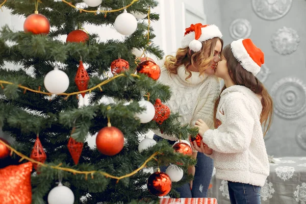 Mother with cute daughter standing near christmas tree — Stock Photo, Image