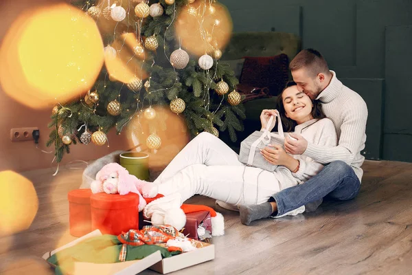 Cute rodziny siedzi w domu w pobliżu choinki — Zdjęcie stockowe