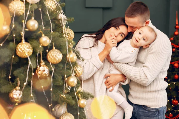 Familia sentada en casa cerca del árbol de Navidad — Foto de Stock