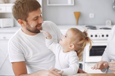 Aile mutfakta oturur ve kurabiye için hamur pişirir.