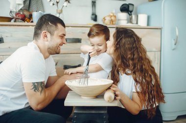 Küçük oğlu mutfakta olan bir aile.