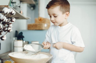 Mutfakta oturan şirin küçük çocuk.