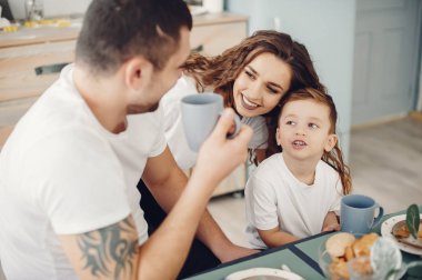 Sevgi dolu aile evde bir mutfakta oturuyor.