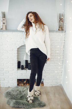 Evde kalın bir kazak içinde sevimli bir kız.