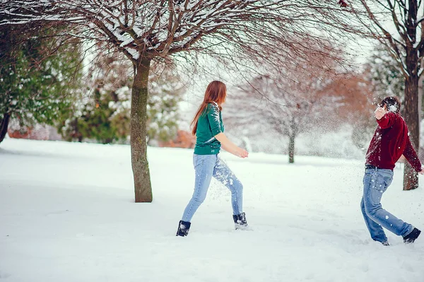 Casal bonito se divertir em um parque de inverno — Fotografia de Stock