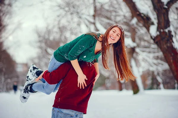 Casal bonito se divertir em um parque de inverno — Fotografia de Stock