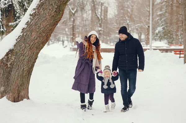 Little girl with parents in a winter park — Stock Photo, Image