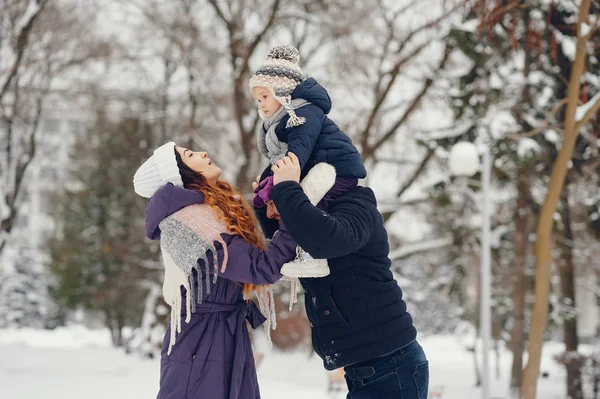 Bambina con i genitori in un parco invernale — Foto Stock