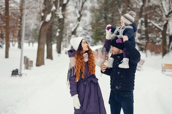 Маленька дівчинка з батьками в зимовому парку — стокове фото