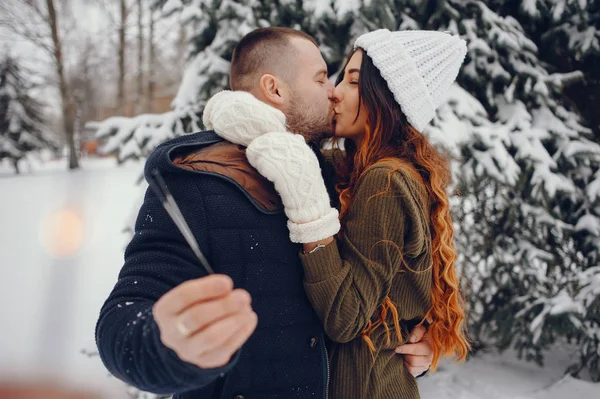 Beutiful woman in a winter park with her husband — Stock Photo, Image