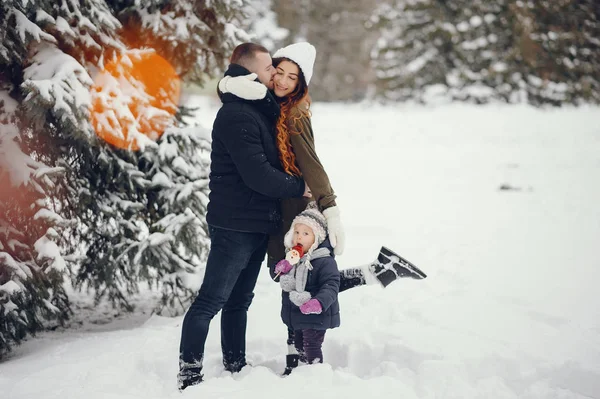 Bambina con i genitori in un parco invernale — Foto Stock