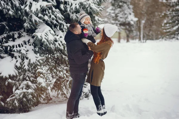 Маленькая девочка с родителями в зимнем парке — стоковое фото