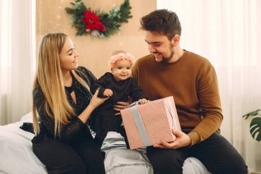 Aile evde oturuyor, hediyelerle dolu bir yatakta.