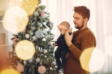 Noel ağacının yanında tatlı kızı olan bir baba.