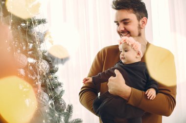 Noel ağacının yanında tatlı kızı olan bir baba.