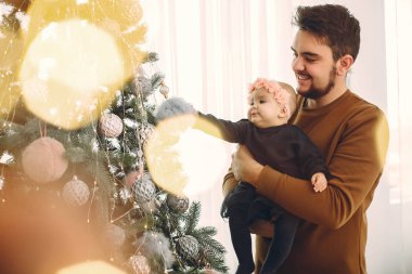 Noel ağacının yanında tatlı kızı olan bir baba.