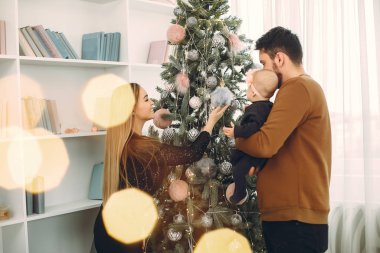 Aile Noel ağacının yanında oturuyor.