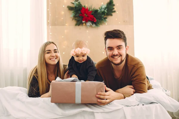 Familie sitzt zu Hause auf einem Bett mit Geschenken — Stockfoto