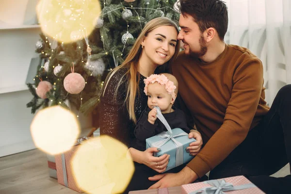 Familie sitzt zu Hause am Weihnachtsbaum — Stockfoto