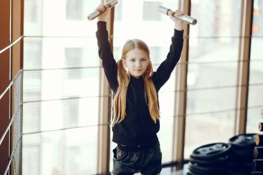 Güzel küçük bir kız bir spor salonunda nişanlanıyor.