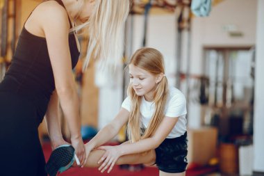 Anne ve kızı spor salonunda oynuyorlar.