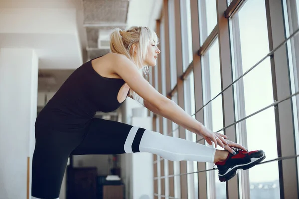 Una hermosa chica se dedica a un gimnasio — Foto de Stock