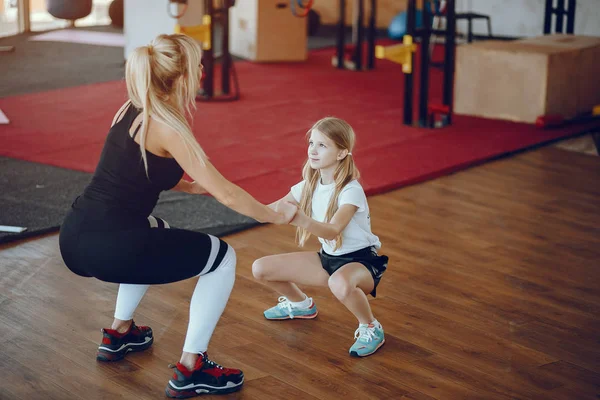 Mutter mit süßer Tochter treibt Sport in der Turnhalle — Stockfoto